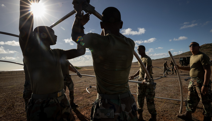 Leden van de Caribische militie bouwen boogtent